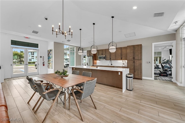 dining area with lofted ceiling, wood tiled floor, visible vents, and french doors