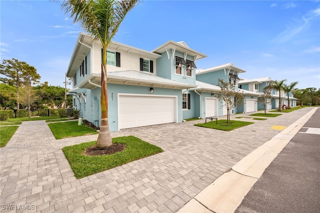 view of front of home featuring a garage, decorative driveway, and fence