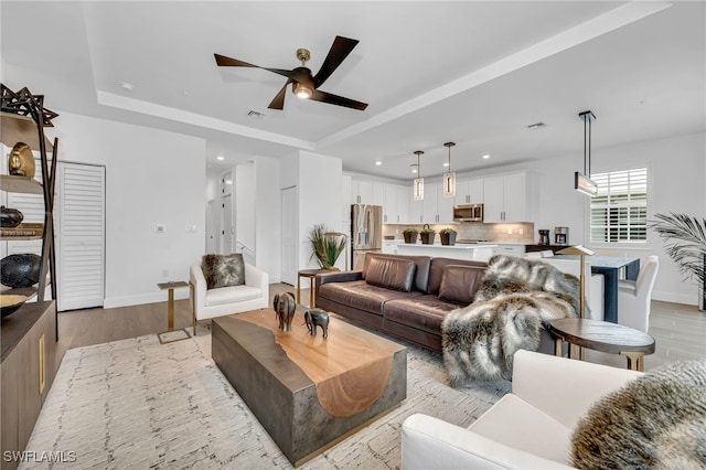 living area featuring recessed lighting, visible vents, light wood-style floors, ceiling fan, and baseboards