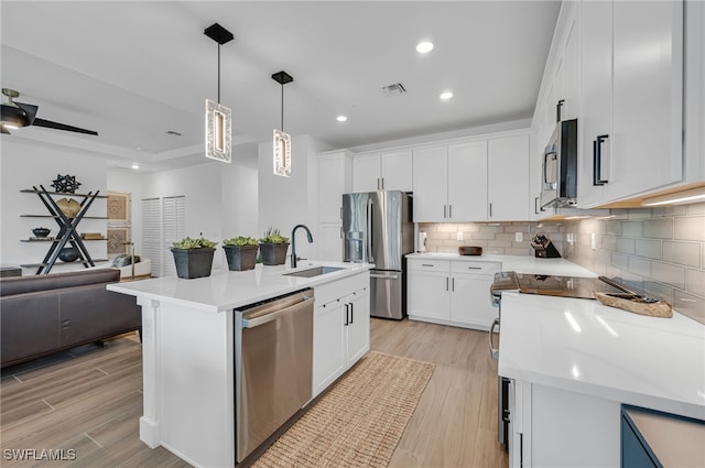 kitchen featuring a sink, visible vents, open floor plan, appliances with stainless steel finishes, and tasteful backsplash