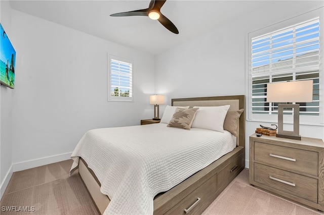 bedroom with baseboards, ceiling fan, and light colored carpet