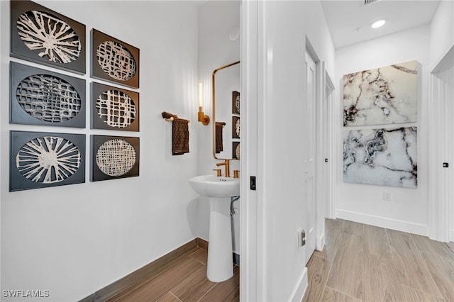 bathroom with recessed lighting, baseboards, and wood finished floors