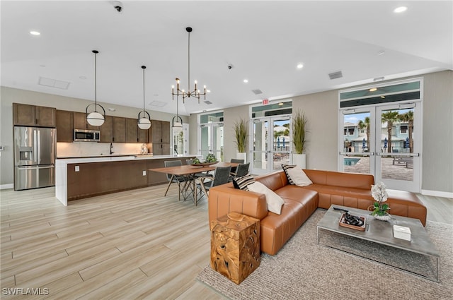 living area featuring recessed lighting, french doors, visible vents, and light wood finished floors