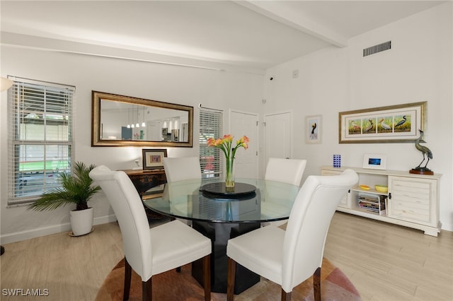 dining area with visible vents, lofted ceiling with beams, baseboards, and wood finished floors