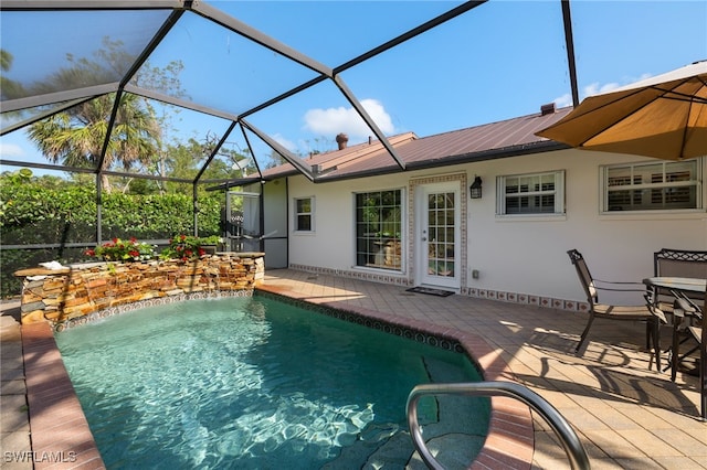 outdoor pool with glass enclosure and a patio area