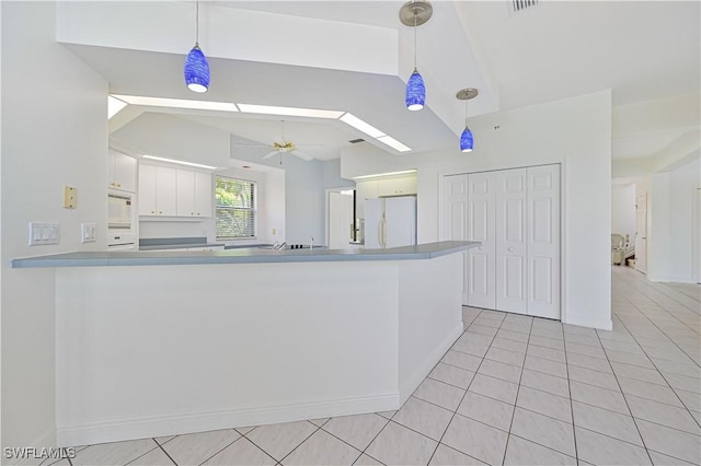 kitchen with white appliances, ceiling fan, decorative light fixtures, a peninsula, and white cabinetry