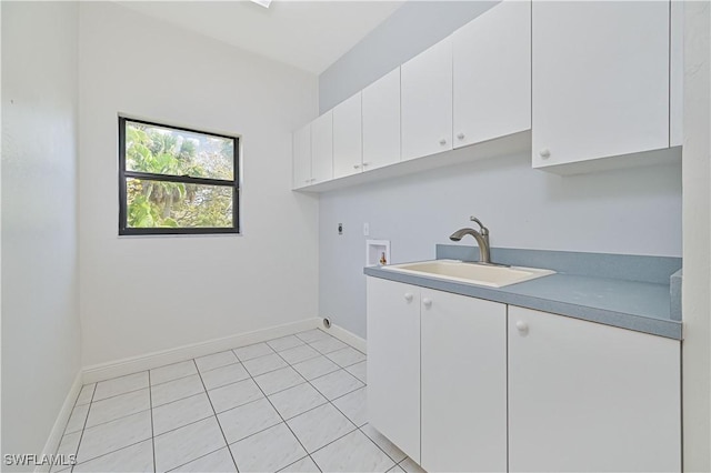 washroom with hookup for an electric dryer, washer hookup, a sink, baseboards, and cabinet space