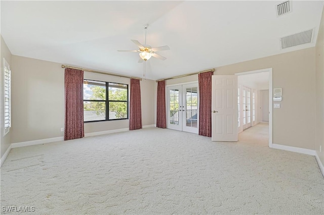 unfurnished room featuring light carpet, french doors, vaulted ceiling, and visible vents