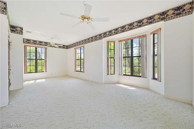 spare room featuring ceiling fan, carpet flooring, visible vents, and baseboards