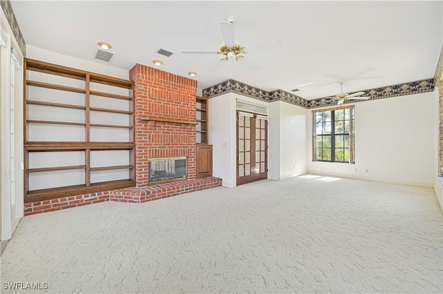 unfurnished living room featuring a ceiling fan, visible vents, a fireplace, and carpet flooring