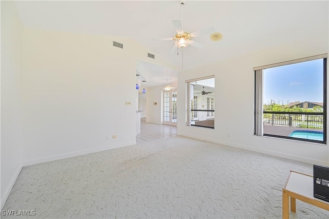 empty room with lofted ceiling, baseboards, light carpet, and visible vents