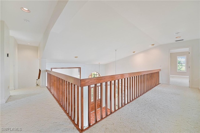 hallway featuring baseboards, visible vents, lofted ceiling, carpet flooring, and recessed lighting