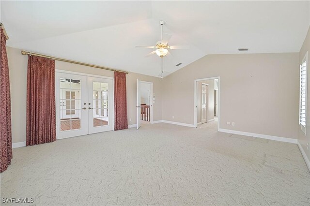 spare room featuring baseboards, a ceiling fan, light colored carpet, lofted ceiling, and french doors