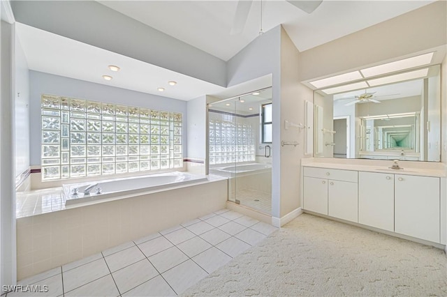 bathroom with a garden tub, a stall shower, ceiling fan, vanity, and tile patterned flooring