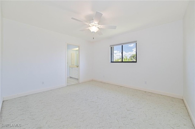 spare room featuring baseboards, a ceiling fan, and light colored carpet