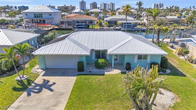 8 Bayview Blvd, Fort Myers Beach, FL 33931 - view of front facade featuring an attached garage, driveway, metal roof, and a water view