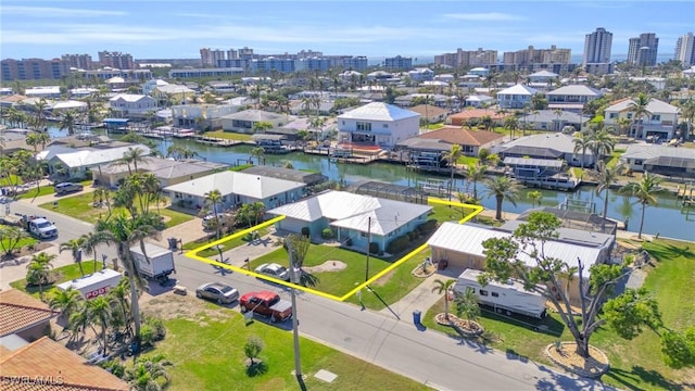 drone / aerial view featuring a water view, a view of city, and a residential view