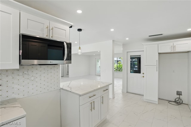 8 Bayview Blvd, Fort Myers Beach, FL 33931 - kitchen with marble finish floor, light stone counters, recessed lighting, pendant lighting, and white cabinets