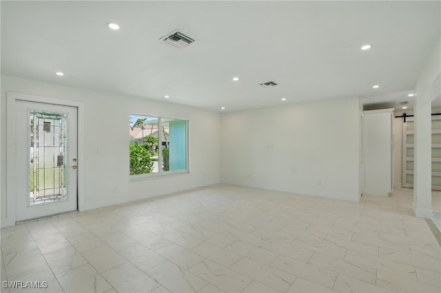 8 Bayview Blvd, Fort Myers Beach, FL 33931 - empty room featuring marble finish floor, a barn door, visible vents, and recessed lighting