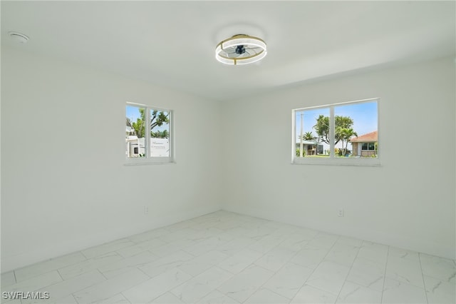 8 Bayview Blvd, Fort Myers Beach, FL 33931 - empty room with a wealth of natural light, marble finish floor, and a ceiling fan