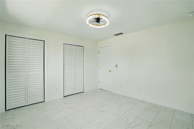 8 Bayview Blvd, Fort Myers Beach, FL 33931 - unfurnished bedroom with marble finish floor, baseboards, multiple closets, and visible vents