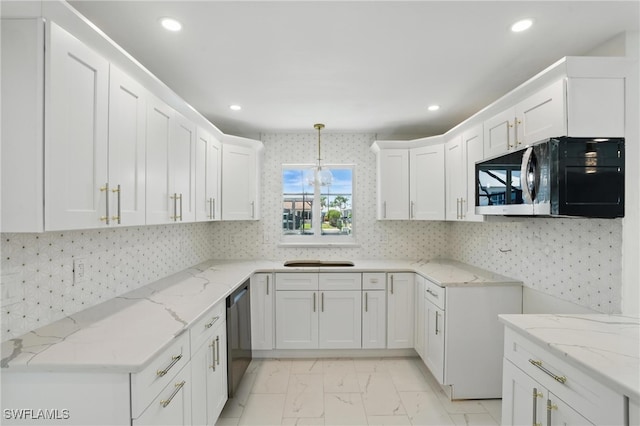 8 Bayview Blvd, Fort Myers Beach, FL 33931 - kitchen with white cabinetry, light stone countertops, black microwave, and recessed lighting