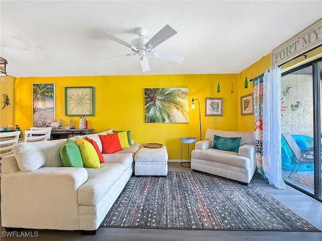 living area with ceiling fan and baseboards