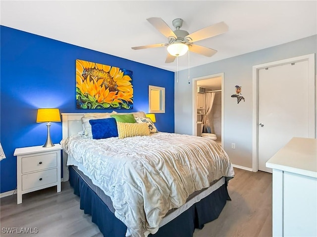 bedroom featuring ceiling fan, connected bathroom, baseboards, and wood finished floors