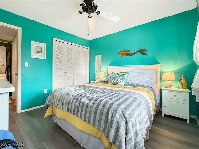 bedroom with dark wood-type flooring, a closet, a ceiling fan, and baseboards