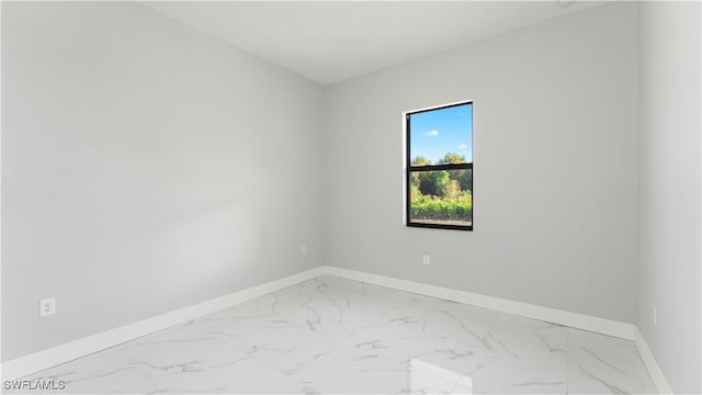 spare room featuring baseboards and marble finish floor