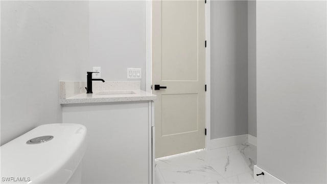 bathroom featuring a sink, baseboards, and marble finish floor