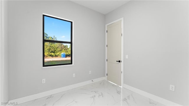 empty room featuring baseboards and marble finish floor