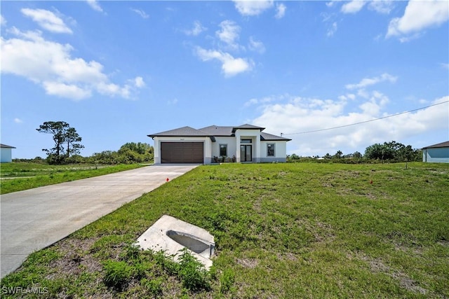 view of front of property featuring a front yard, concrete driveway, and an attached garage