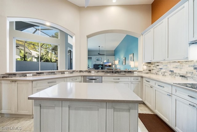 kitchen featuring tasteful backsplash, a center island, black electric stovetop, light countertops, and white cabinets