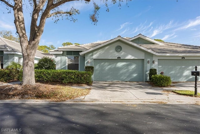 single story home with concrete driveway, a garage, and stucco siding