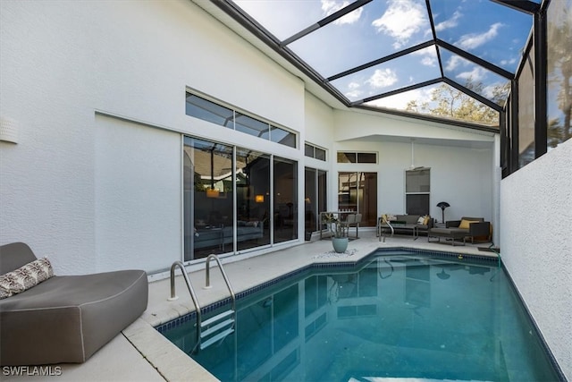 pool with outdoor lounge area, glass enclosure, and a patio area