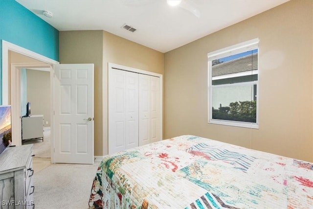 bedroom with visible vents, light colored carpet, a closet, and ceiling fan