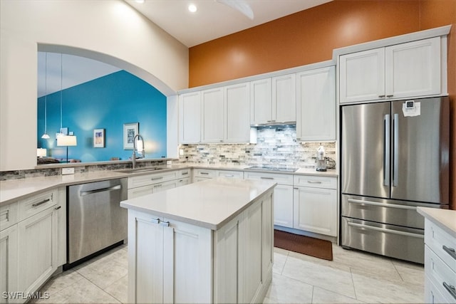 kitchen with a sink, light countertops, appliances with stainless steel finishes, white cabinetry, and backsplash