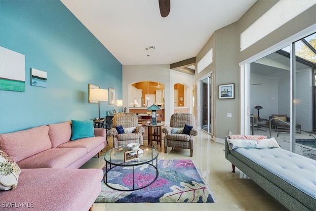 living area featuring vaulted ceiling, baseboards, and arched walkways