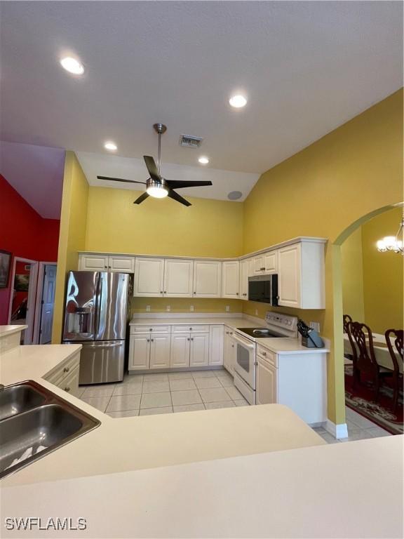 144 Carlisle Ave S, Lehigh Acres, FL 33974 - kitchen featuring white cabinets, arched walkways, ceiling fan, and stainless steel appliances
