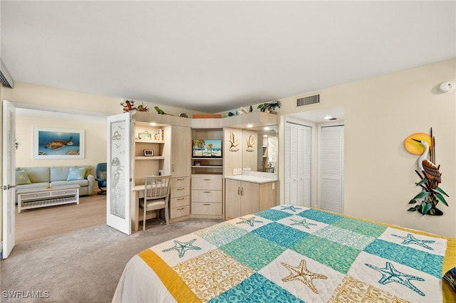 bedroom featuring light carpet, two closets, and visible vents