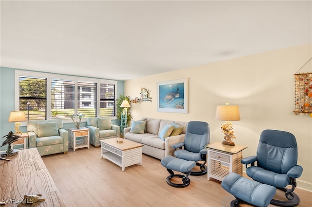 living area with baseboards and light wood finished floors