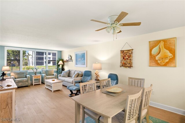 dining area with baseboards, ceiling fan, and light wood-style floors