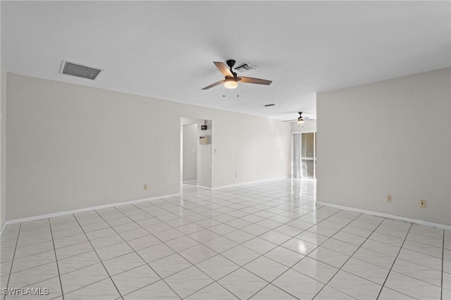 spare room with ceiling fan, visible vents, and baseboards