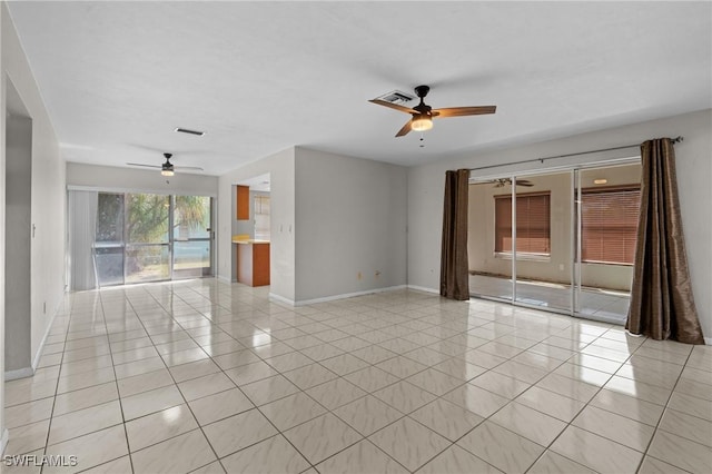 spare room featuring light tile patterned flooring, ceiling fan, visible vents, and baseboards