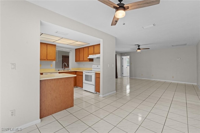 kitchen featuring white range with electric cooktop, light countertops, brown cabinetry, open floor plan, and under cabinet range hood