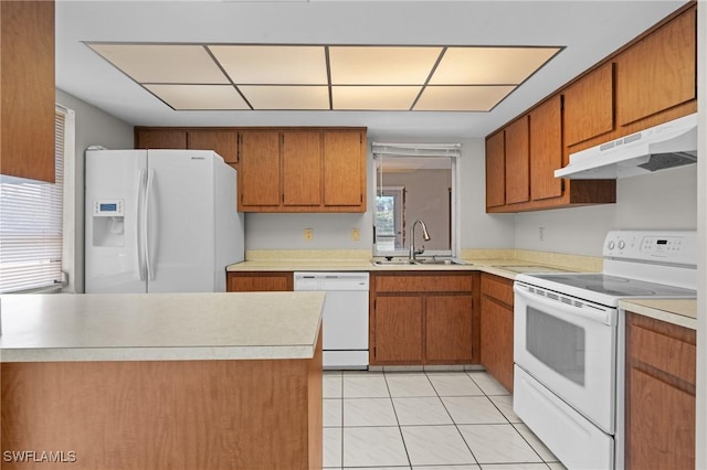 kitchen featuring white appliances, light countertops, a sink, and under cabinet range hood