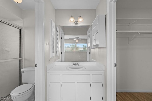 full bathroom with ceiling fan, toilet, wood finished floors, vanity, and a closet