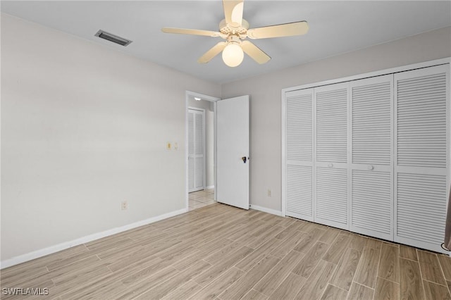 unfurnished bedroom with baseboards, visible vents, a ceiling fan, light wood-style floors, and a closet