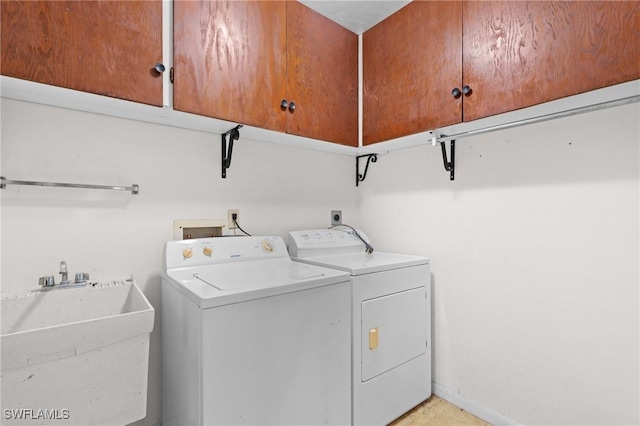 laundry room with separate washer and dryer, a sink, cabinet space, and baseboards